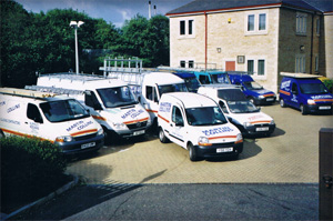 Historic photo of Martin Collins Joinery vans lined up on a forecourt